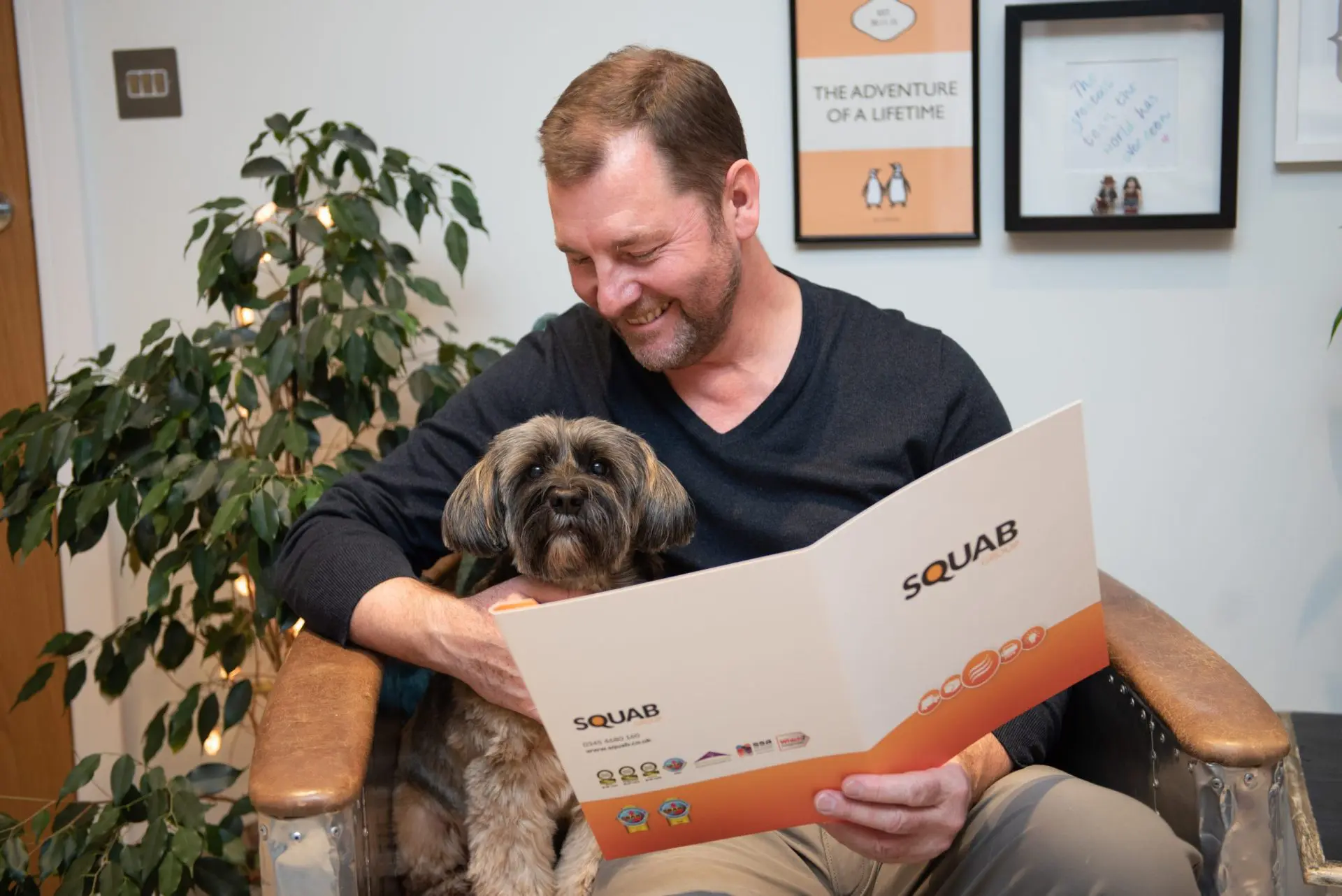 A man reading book with a dog